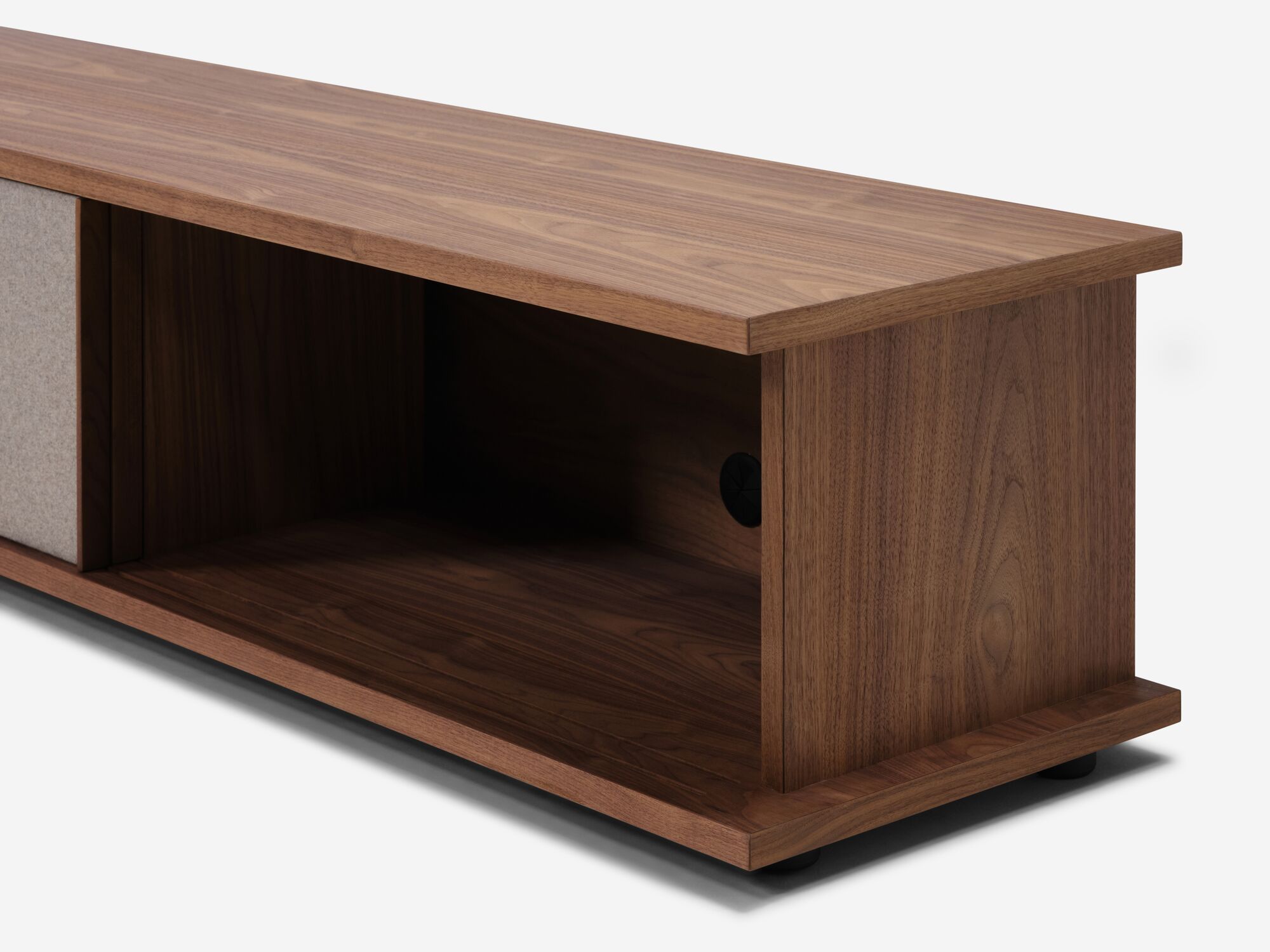 Angled view of the Plank mid century media console in walnut with fabric paneled door open